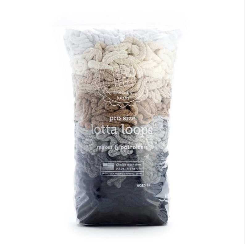 May include: A clear plastic bag filled with pro size "lotta loops" in a gradient of colors from white to dark gray. The bag has text that reads "makes 6 potholders" and "Quality cotton loops MADE IN THE USA".