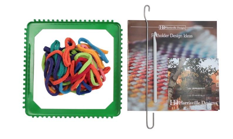 May include: A green plastic loom with colorful yarn in the center. A metal hook and a booklet titled "Flotholder Design Ideas" by Harrisville Designs are also included.