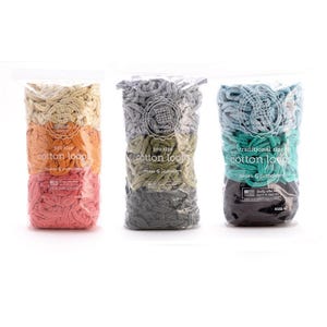 May include: Three clear plastic bags filled with colorful cotton loops for crafting. The bags are labeled with text indicating the size and the number of pot holders that can be made. The loops are in shades of pink, orange, green, gray, and teal.