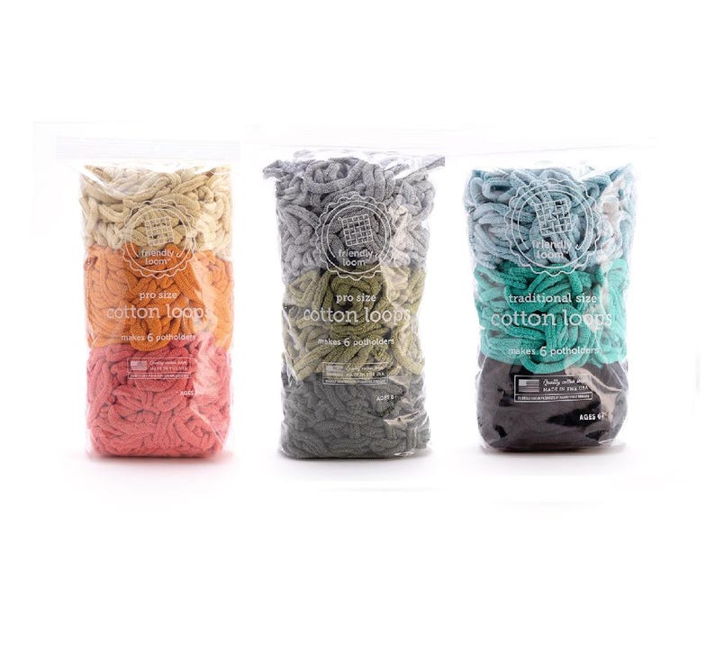 May include: Three clear plastic bags filled with colorful cotton loops for crafting. The bags are labeled with text indicating the size and the number of pot holders that can be made. The loops are in shades of pink, orange, green, gray, and teal.