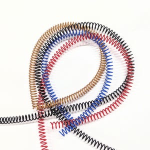 May include: Four coiled metal binding spines in black, red, blue, and gold.