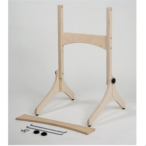 以下が含まれることがあります： 高さ調節可能な木製イーゼルスタンドで、上部に湾曲したバーが付いています。スタンドは自然な木製の仕上げで、両側に3本の脚で支えられています。