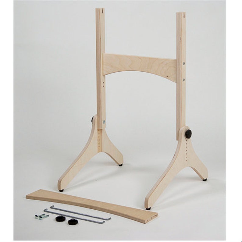 以下が含まれることがあります： 高さ調節可能な木製イーゼルスタンドで、上部に湾曲したバーが付いています。スタンドは自然な木製の仕上げで、両側に3本の脚で支えられています。