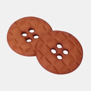 May include: A white ceramic mug with a black handle and the text "But First, Coffee" in a bold, black font. The mug is filled with a dark liquid, likely coffee, and sits on a light-colored surface.