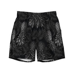 May include: Black and white shorts featuring an all-over monochromatic pattern of pineapples and tropical palm leaves. The garment has an elasticized waistband and a relaxed fit, showcasing a repeating botanical print in shades of gray and black.