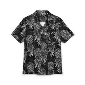 Può includere: Camicia nera a maniche corte con un motivo ripetuto di ananas in scala di grigi. La camicia ha un colletto classico e una vestibilità rilassata. Il design dell'ananas aggiunge un tocco tropicale, adatto all'abbigliamento casual.