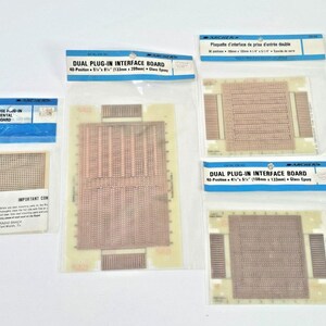 May include: Four circuit boards for electronics projects. Two are labeled "Dual Plug-In Interface Board" and one is labeled "Multi-Purpose Plug-In Experimental Breadboard".