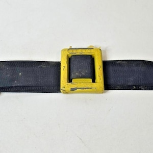 May include: A black weight belt with three yellow metal weight holders. The belt is made of a durable, woven material. The yellow holders have a square shape and are slightly worn.