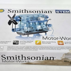 May include: A Smithsonian Motor-Works STEM kit box. The box features a transparent model of a 4-cylinder engine, a propeller, and the text "Motor-Works". Includes a 36" x 22" color poster.