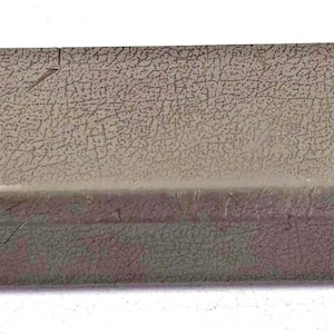 Puede incluir: Una cubierta rectangular de plástico color topo con una superficie texturizada. El borde superior presenta dos mecanismos de cierre negros y la palabra OPEN impresa dos veces, cada una con una flecha que apunta hacia abajo.