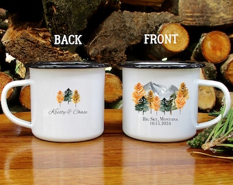 Könnte beinhalten: Zwei weiße Emailletassen mit schwarzen Rändern. Die Tasse links trägt den Text "Kristy & Chase" und ein Aquarellbild von drei Bäumen. Die Tasse rechts trägt den Text "Big Sky, Montana 10.15.2024" und ein Aquarellbild von Bergen und Bäumen.