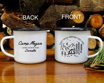 Könnte beinhalten: Weißer Emaille-Campingbecher mit schwarzem Rand und Henkel. Die Vorderseite zeigt ein Berg- und Zelt-Design mit dem Text "LAST TRAIL BEFORE THE VEIL". Auf der Rückseite steht der Text "Camp Megan LAKE TAHOE 2026 Danielle".