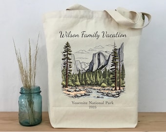 Könnte beinhalten: Eine weiße Canvas-Tragetasche mit einer schwarzen Illustration einer Bergkette und Bäumen. Der Text "Wilson Family Vacation" ist oben auf der Tasche in Schwarz gedruckt. Der Text "Yosemite National Park 2025" ist unten auf der Tasche in Schwarz gedruckt.