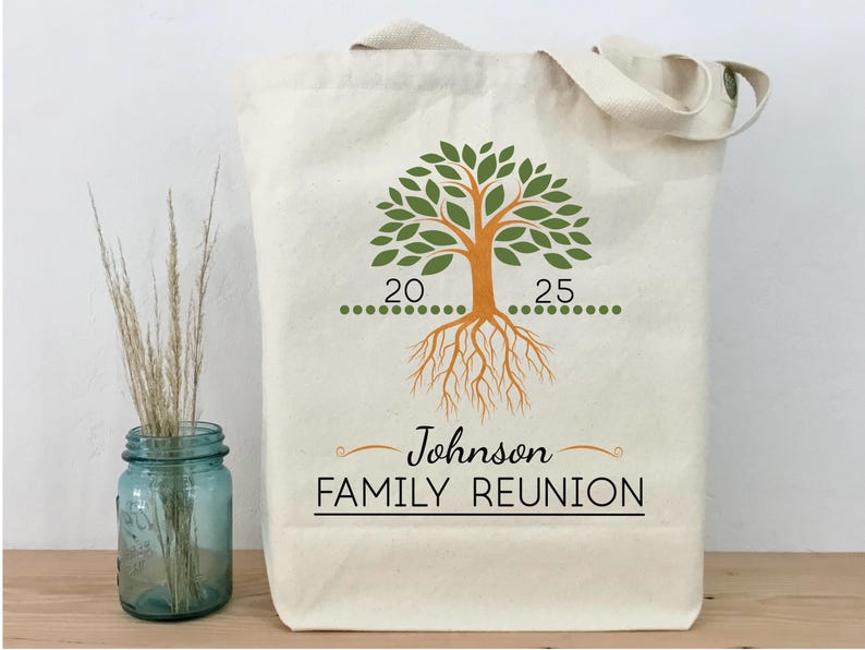 May include: A white canvas tote bag with a green tree design and brown roots. The tree has two numbers on it, 20 and 25. The text "Johnson FAMILY REUNION" is printed on the bag.