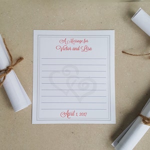 May include: A white card with a gray border and gray lines. The card has the text "A Message for Victor and Lisa" and "April 1, 2017" in red cursive font. There are two gray hearts in the center of the card.