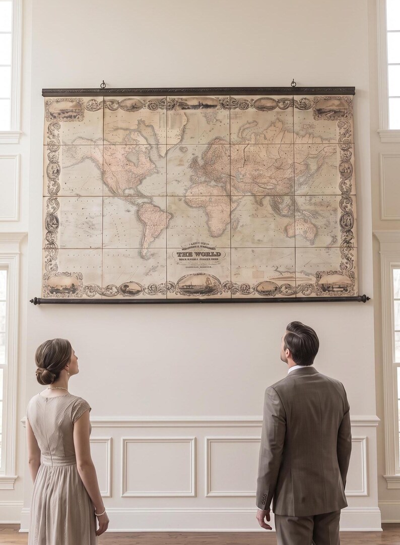 A large empty wall is transformed with a stunning oversized world map canvas. A happily married couple stands together, admiring their beautiful wedding gift with smiles and excitement.
