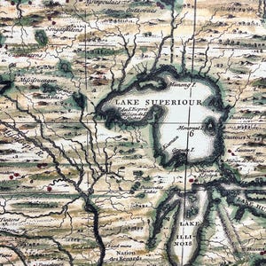 Puede incluir: Un mapa antiguo de la regi&oacute;n de los Grandes Lagos de Am&eacute;rica del Norte, con texto escrito a mano en franc&eacute;s e ingl&eacute;s. El mapa muestra la ubicaci&oacute;n de varias tribus nativas americanas, r&iacute;os y lagos, incluyendo el lago Superior, el lago Hur&oacute;n y el lago Illinois. El mapa est&aacute; dibujado con tinta marr&oacute;n, verde y negra sobre un fondo crema.