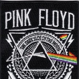 May include: Black embroidered patch featuring the words "PINK FLOYD" above a geometric design. The design includes a triangle, a circle, and a rainbow, with the text "THE DARK SIDE OF THE MOON".