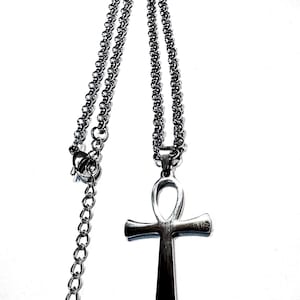 Peut inclure: Collier pendentif ankh argenté. L'ankh, symbole de vie, est suspendu à une chaîne délicate. Le collier est doté d'un fermoir mousqueton et d'une chaîne réglable pour un ajustement personnalisé. Le pendentif ankh a une finition polie.