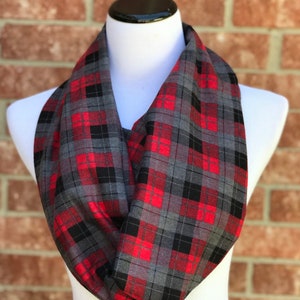 May include: A red and gray plaid infinity scarf. The scarf is made of a soft, comfortable fabric and is perfect for keeping warm in the winter.