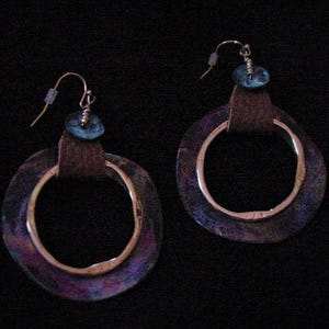 May include: A pair of iridescent blue and purple hoop earrings with a smaller blue bead accent on each earring.