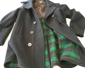 May include: A navy blue peacoat with a plaid lining. The coat has a double breasted closure and four buttons.