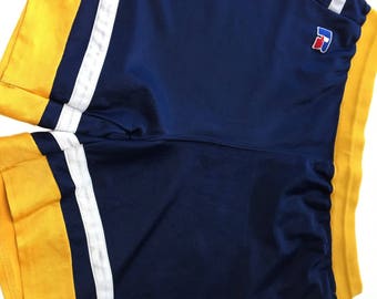 May include: Blue and yellow basketball shorts with white stripes and a small logo on the back.