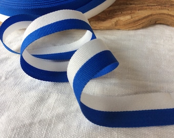 May include: Blue and white striped ribbon. The ribbon is woven with alternating stripes of royal blue and white.