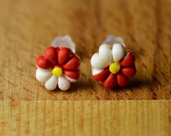 Pendientes pequeños con forma de flor en postes de plástico.