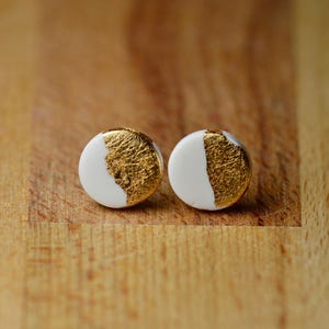 One centimetre round half white half gold leaf polymer clay earrings on plastic posts.