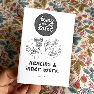 May include: A black and white illustration of a hand holding a crystal, with flowers and leaves. The text "teeny tiny tarot" is in a circle at the top of the image. The text "Healing & inner work" is below the illustration. The text "vol. 4" is at the bottom of the image.