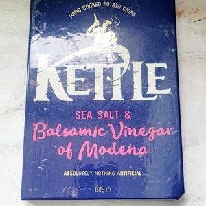 Può includere: Una tazza di ceramica bianca con manico nero e la scritta "But First, Coffee" in nero, con un carattere a mano. La tazza è su una superficie bianca.