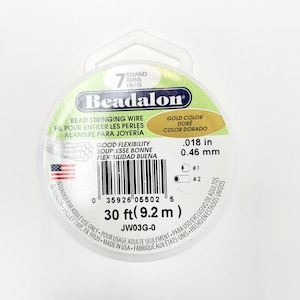 May include: A spool of gold-colored Beadalon bead stringing wire. It is 30 feet (9.2 meters) long and has good flexibility. The label says "Bead Stringing Wire" and "Good Flexibility".
