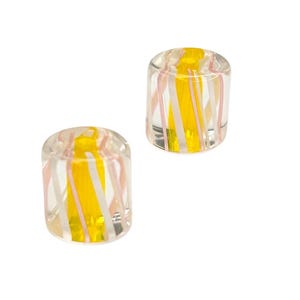 May include: Two clear glass cylinder beads with yellow and pink stripes.