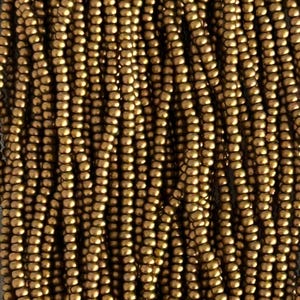 May include: Close-up of a strand of small, round, metallic gold beads. The beads are strung together, creating a textured surface. The beads are evenly spaced and have a consistent size and shape. The image is well-lit, highlighting the beads' reflective quality.