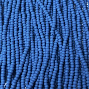 May include: Close-up of numerous strands of small, round, matte blue beads. The beads are strung together, creating a textured, vertical pattern. The color is a vibrant, solid blue, filling the frame. These beads are suitable for jewelry making.