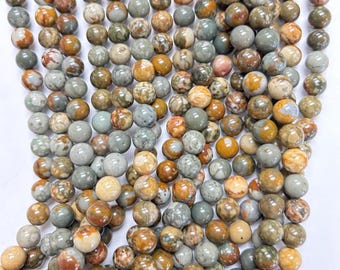 May include: A strand of round, multi-colored, natural gemstone beads. The beads are a mix of brown, tan, gray, and white. The beads are approximately 6mm in diameter.