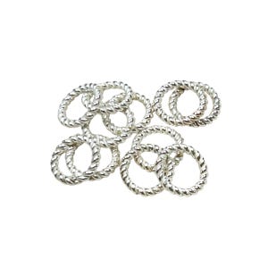 May include: A group of silver jump rings with a twisted rope design. The rings are scattered on a white background.