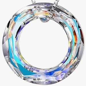 May include: A clear crystal pendant necklace with a round, iridescent, faceted design. The pendant is suspended from a silver chain.