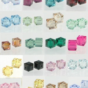 May include: Assortment of 20 pairs of square glass beads in various colors, including light blue, green, pink, brown, black, and clear.