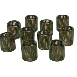 May include: Ten glass beads with a cylindrical shape. Each bead features a pattern of diagonal stripes in shades of green and brown. The beads are arranged on a white background, showcasing their design and color variations.