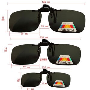 May include: Three pairs of black clip-on sunglasses with polarized lenses. The sunglasses are 13.5 cm wide and 5.7 cm tall. The lenses are dark gray and have a glare blocking label that says "Glare Blocking Polarized".