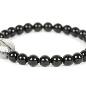 May include: Black beaded bracelet with a clear quartz crystal bead.