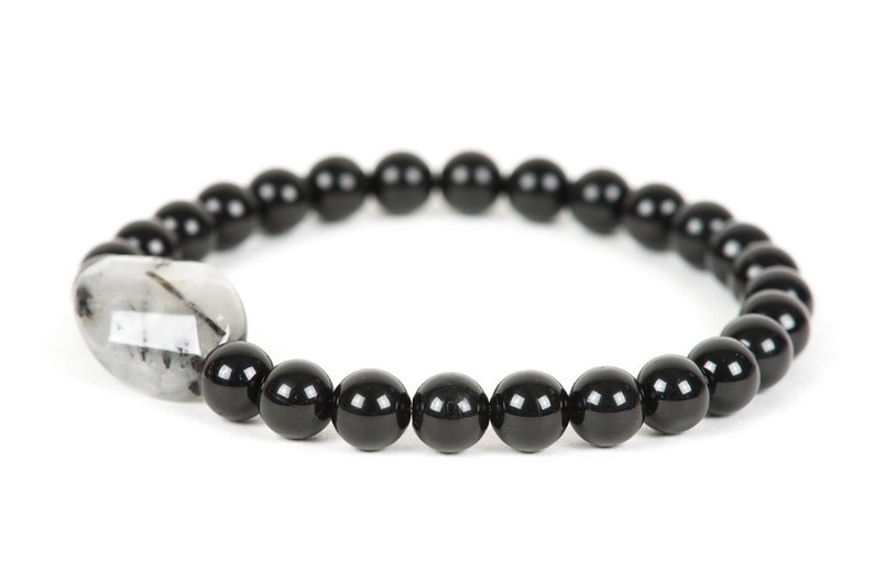 May include: Black beaded bracelet with a clear quartz crystal bead.