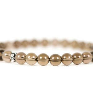 Peut inclure: Un bracelet en perles de quartz fum&eacute; brun avec une perle d'espacement argent&eacute;e.