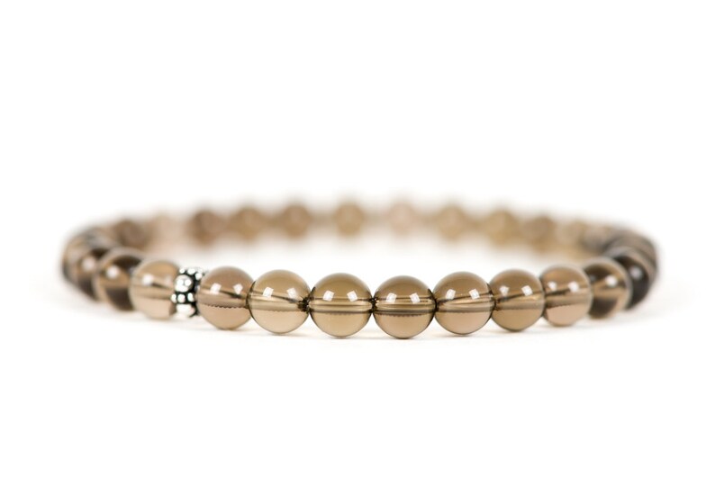 Peut inclure: Un bracelet en perles de quartz fum&eacute; brun avec une perle d'espacement argent&eacute;e.