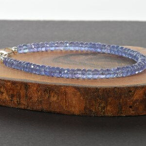 May include: A delicate bracelet made with small, light blue gemstone beads. The bracelet is strung on a silver chain and has a clasp closure.