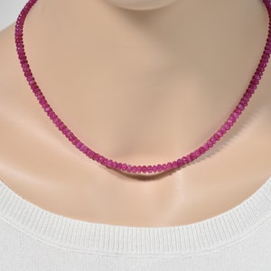 May include: A pink ruby gemstone necklace with small, round beads.