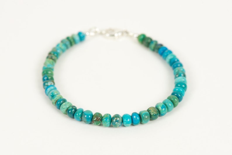 May include: A turquoise and green gemstone beaded bracelet with a silver clasp.