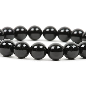May include: A black beaded bracelet with round, smooth beads.
